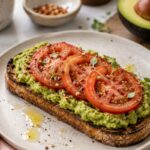 Avocado on toast with sliced tomatoes.