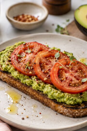 Avocado on toast with sliced tomato.