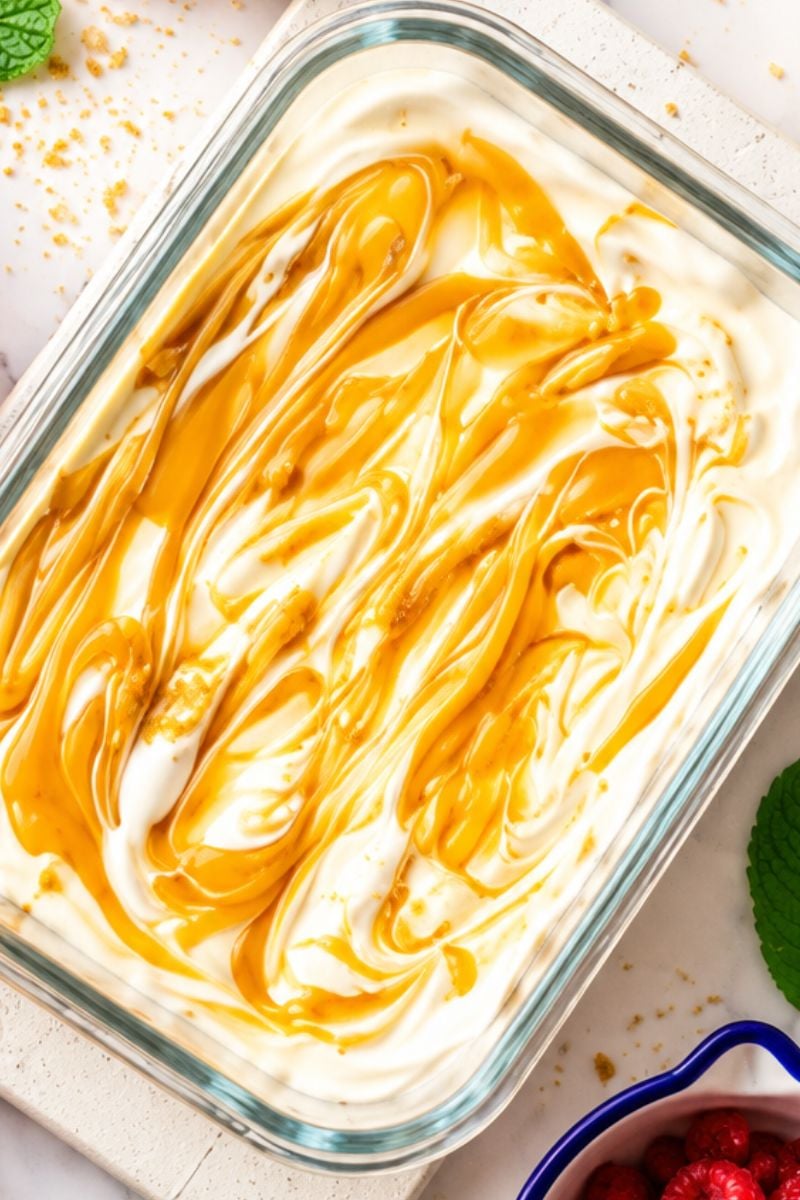 Close-up of creamy overnight Weetabix cheesecake with a smooth Greek yogurt topping and caramel drizzle, a delicious high-protein breakfast.