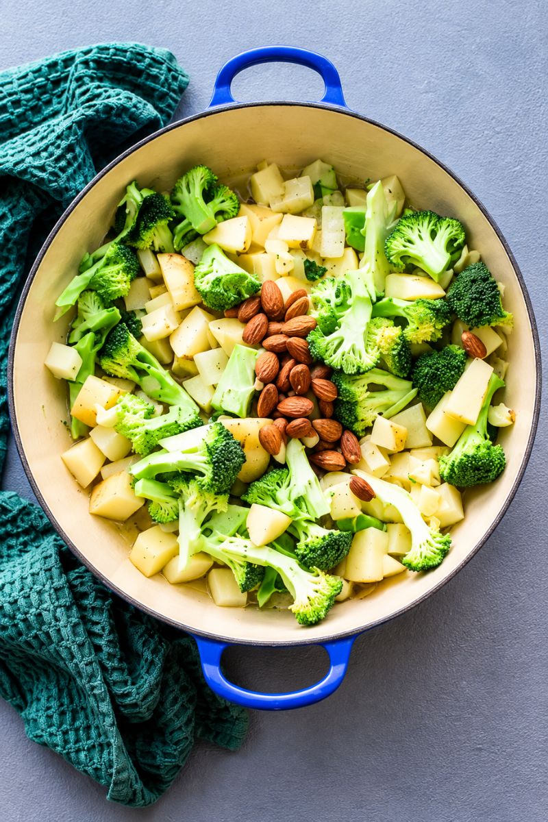 Broccoli florets, diced potatoes and almonds added to the pot
