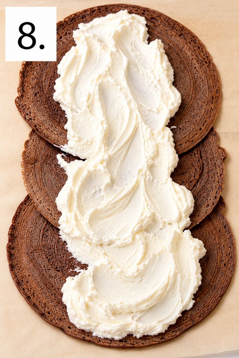 Whipped cream spread over chocolate crepes layered with Nutella.