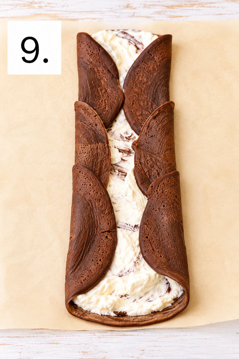 Chocolate crepes folded inward around a creamy whipped cream and Nutella filling.