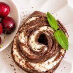 Chocolate crepe roll with layers of whipped cream and Nutella, served with fresh cherries and mint.