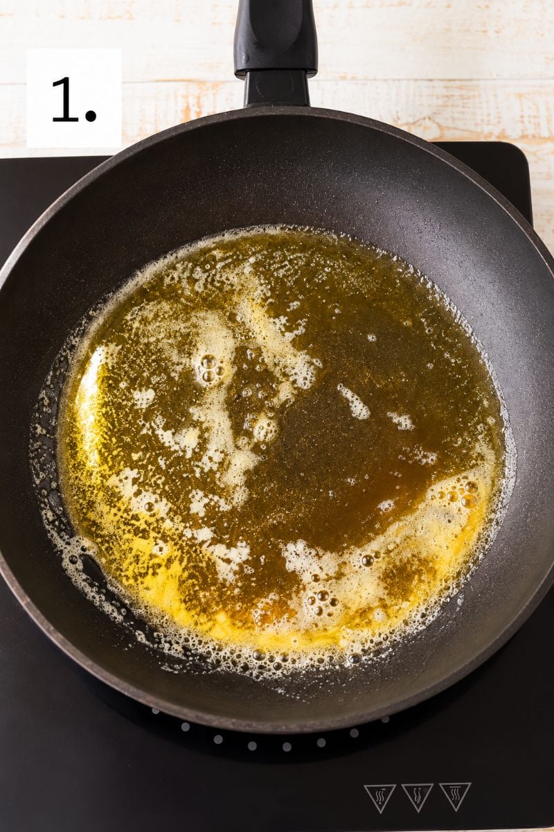 Unsalted butter melting in a nonstick frying pan for homemade chocolate crepes.