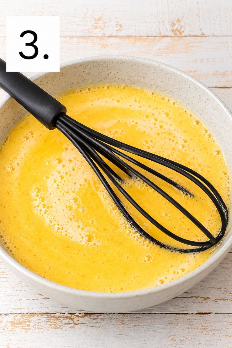 Eggs, milk and metled butter whisked together in a mixing bowl for chocolate crepe batter.