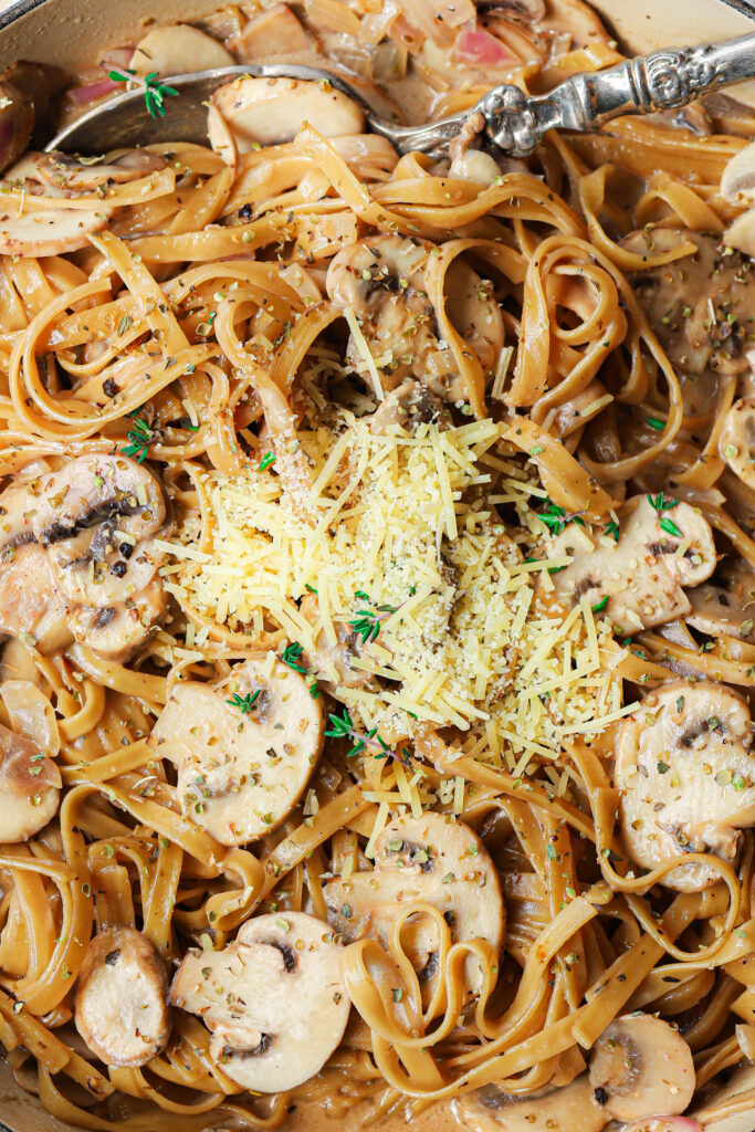 Coconut milk pasta in a pot garnished with herbs.