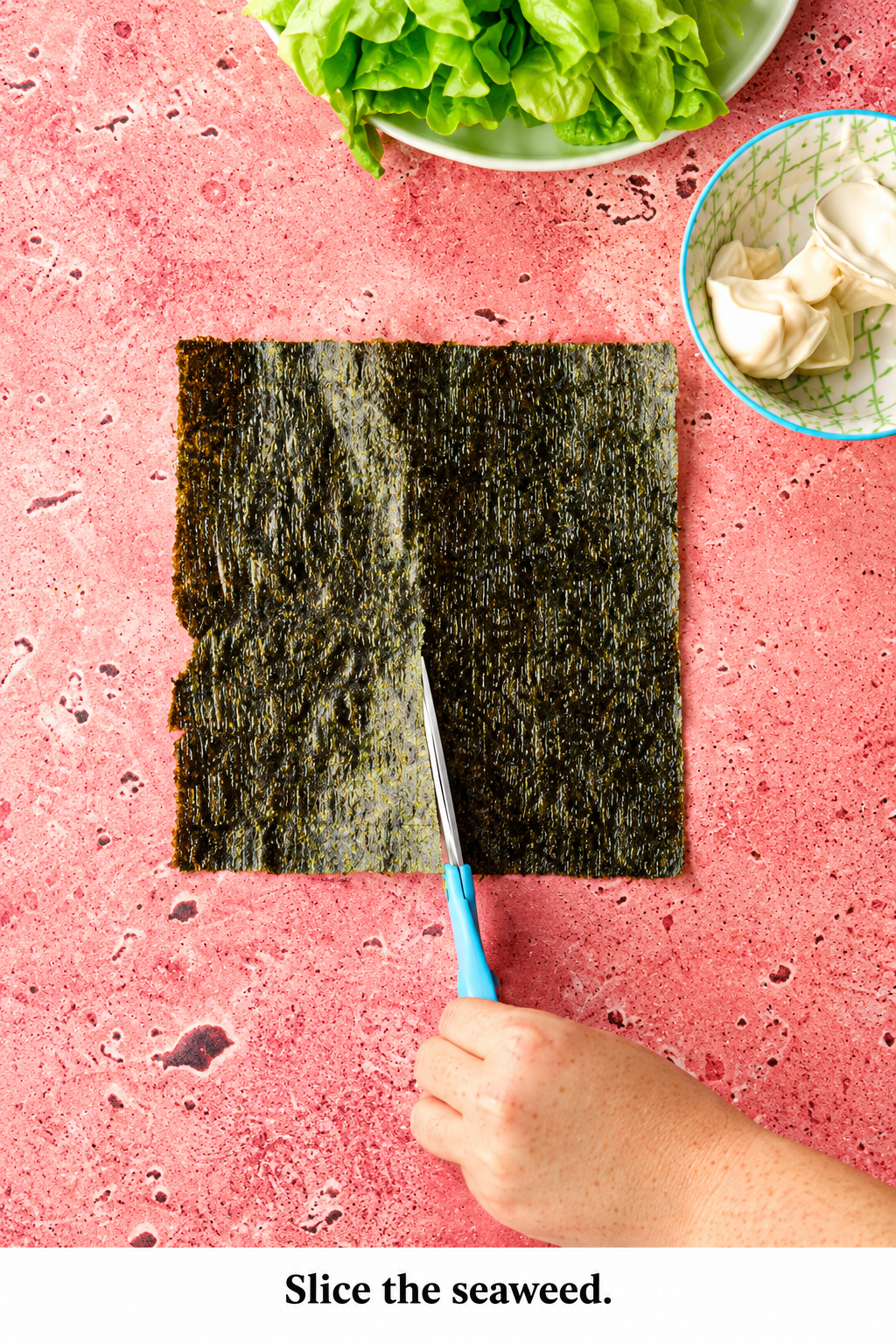 Cutting a nori seaweed sheet with scissors to prepare easy homemade sushi wraps.