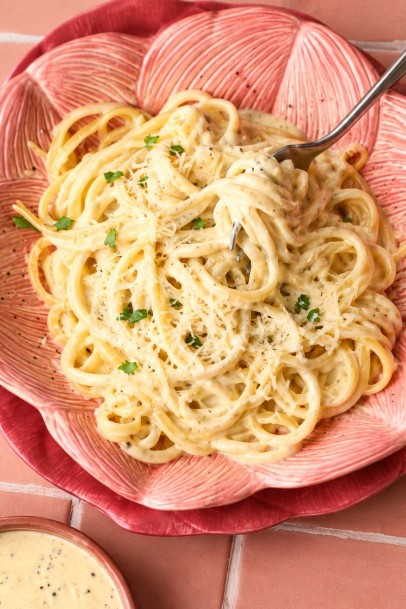 Pasta topped with creamy garlic parmesan sauce and grated Parmesan.