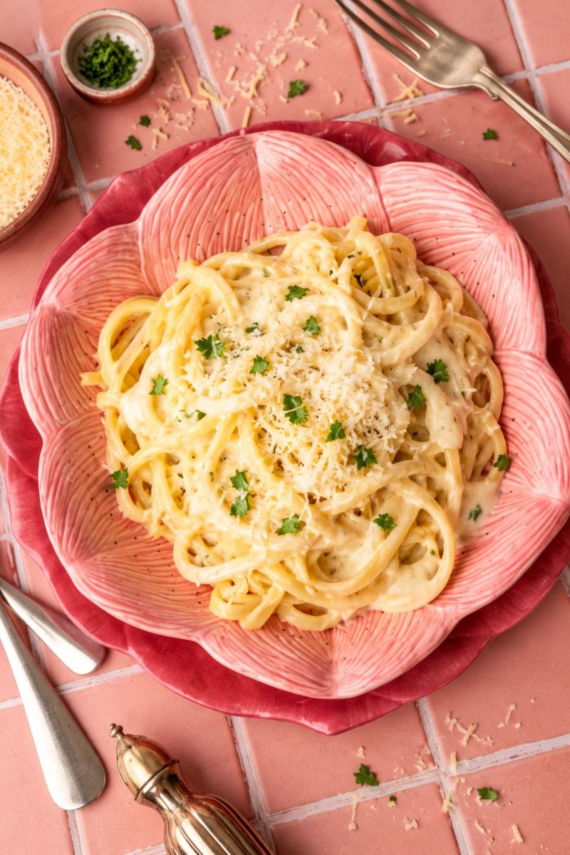 Pasta topped with creamy garlic parmesan sauce and grated Parmesan.