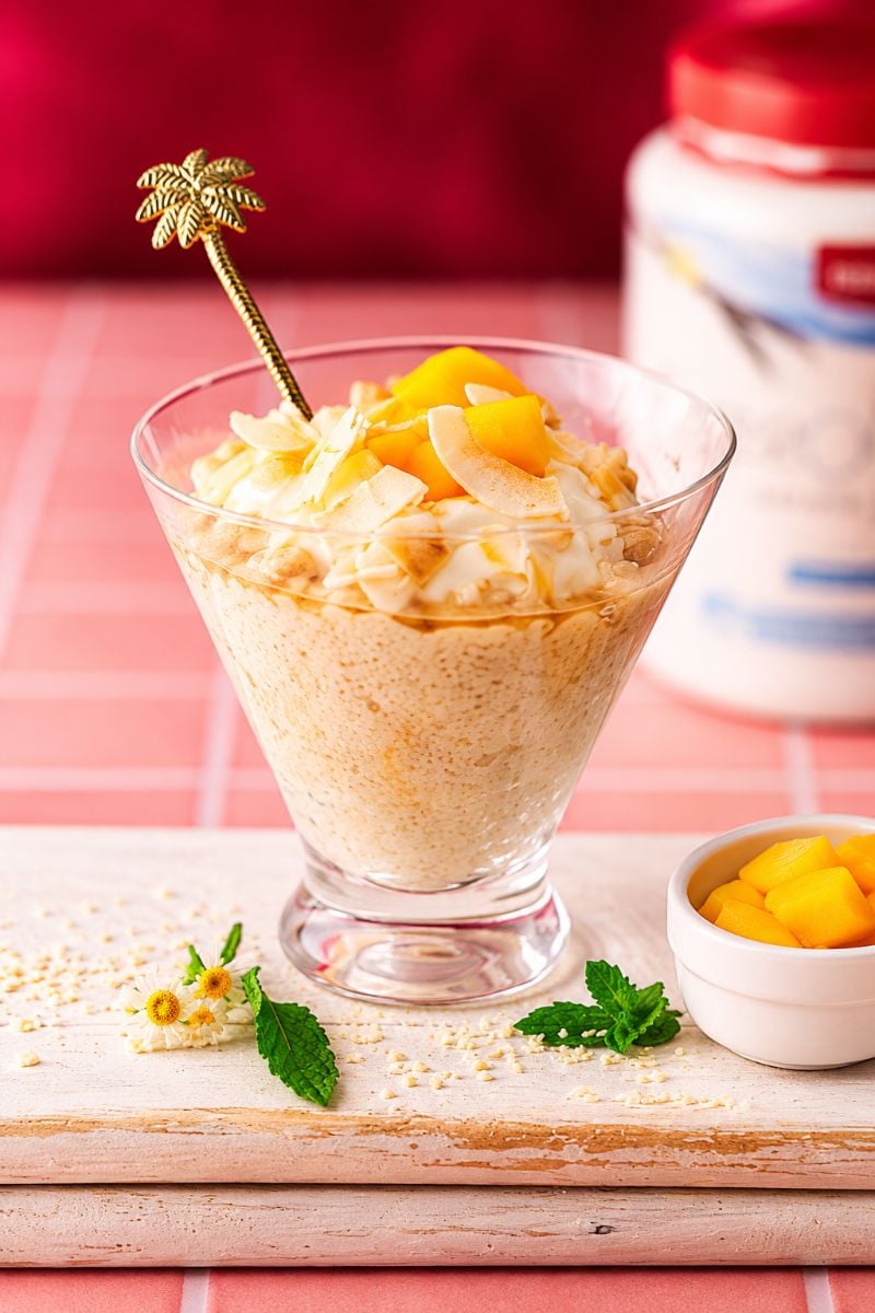 Creamy protein rice pudding topped with fresh mango chunks, yogurt, and toasted coconut flakes.