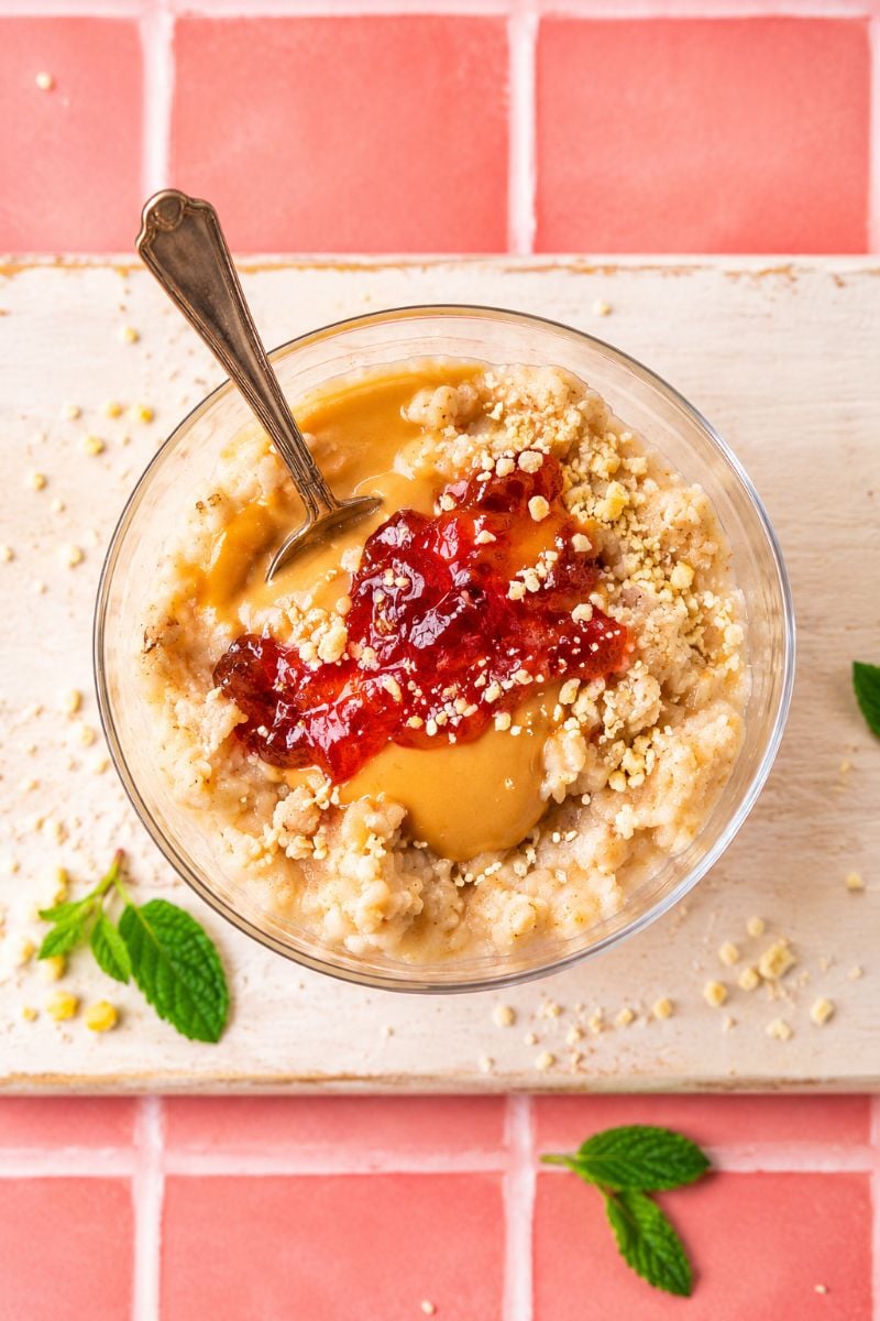 Overhead view of protein rice pudding topped with creamy peanut butter and strawberry jelly.