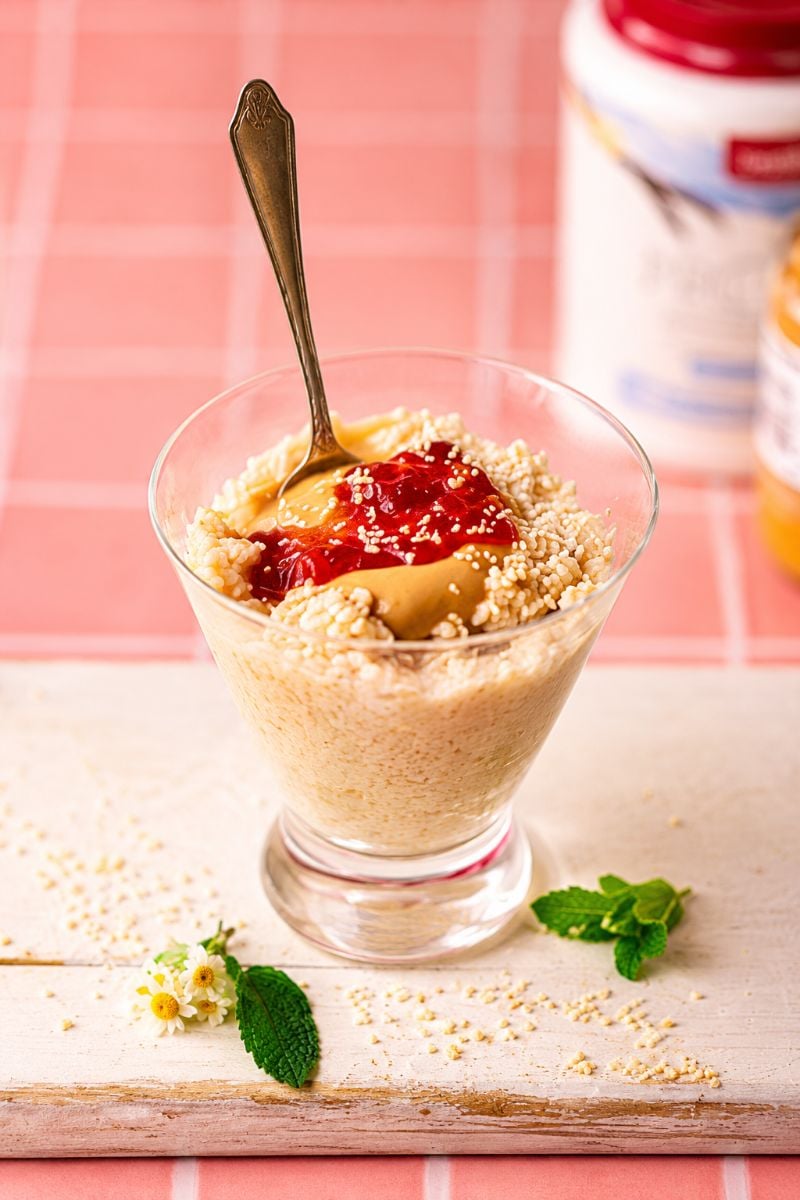 Creamy protein rice pudding topped with peanut butter, strawberry jam, and crushed peanuts.