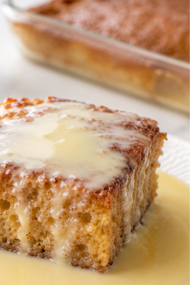 A slice of malva pudding with custard. 