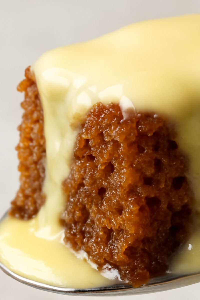 A close picture of malva pudding with custard.