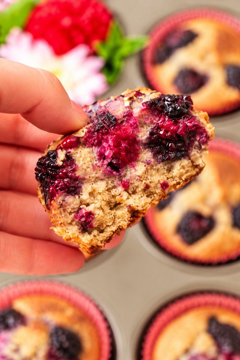 Close-up of a banana blackberry muffin with juicy blackberry filling.
