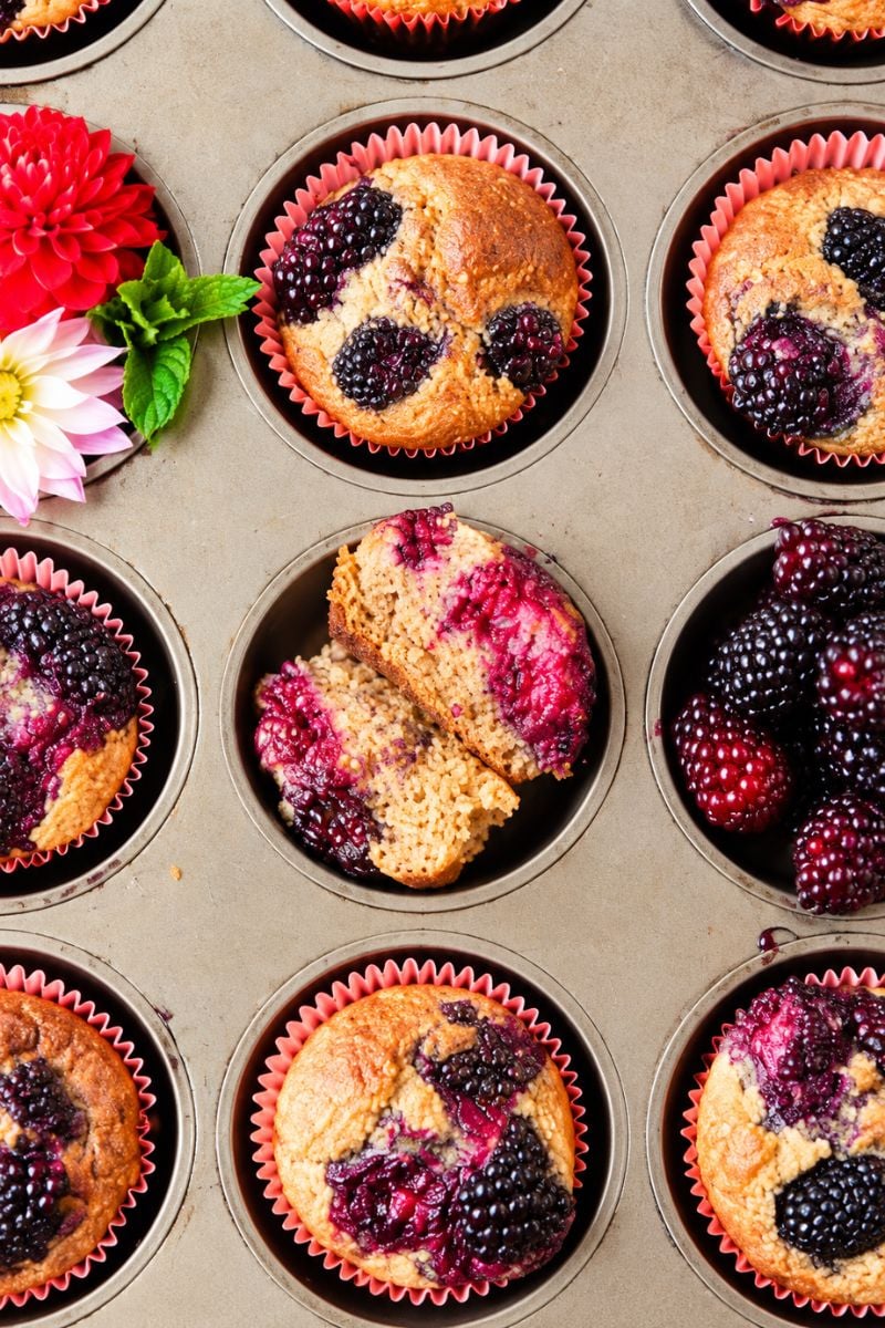 Banana blackberry oatmeal muffins with fresh blackberries in a muffin pan.