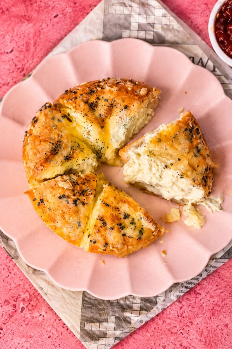 Close-up of a warm stuffed bagel pulled apart to reveal its soft cream cheese filling.