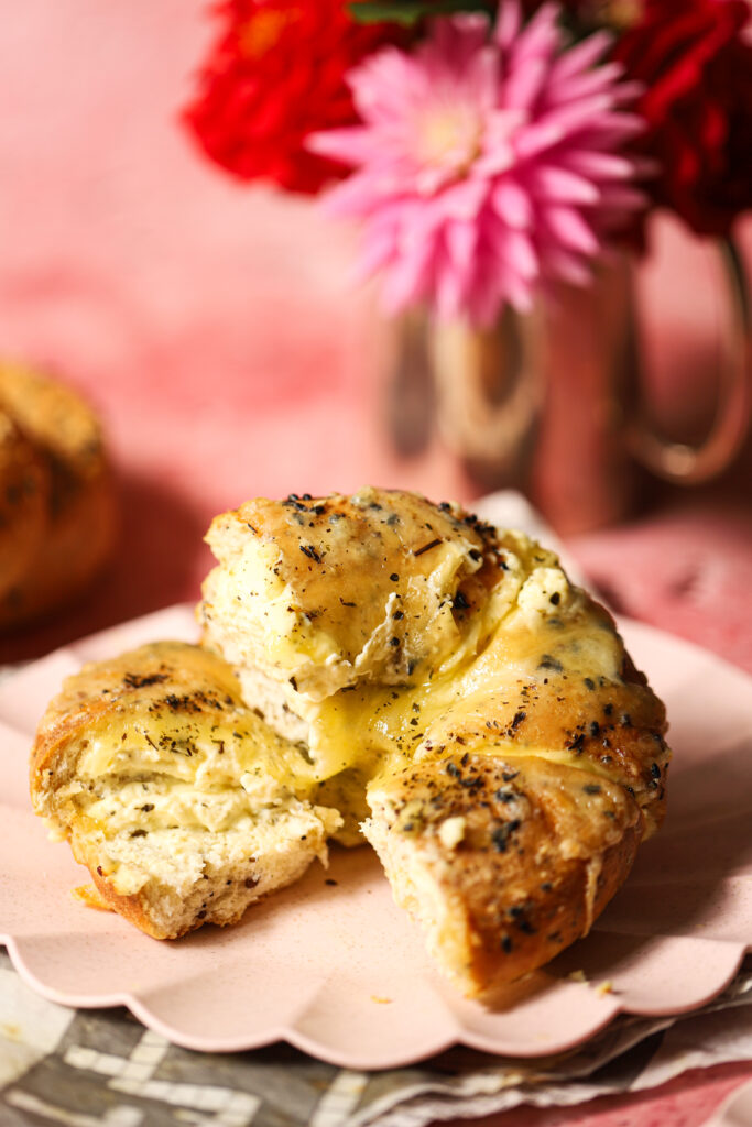 The side view of a stuffed bagel with cream cheese.