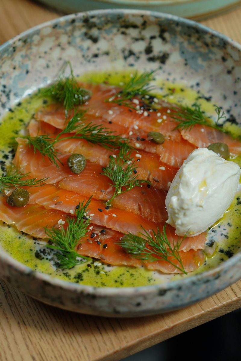 A plate of salmon with dill, lemon juice and olive oil.