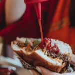 Pour ketchup onto a burger. Substitutes for ketchup.