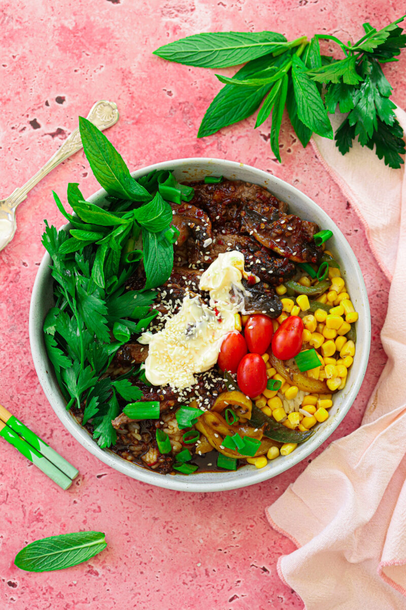Steak and rice bowls with a topping of mayonnaise on the top. 