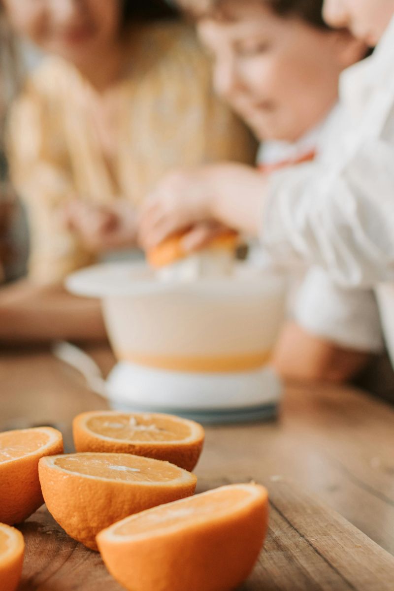 Young children squeezing an orange. Here are 10 substitutes for orange juice. 