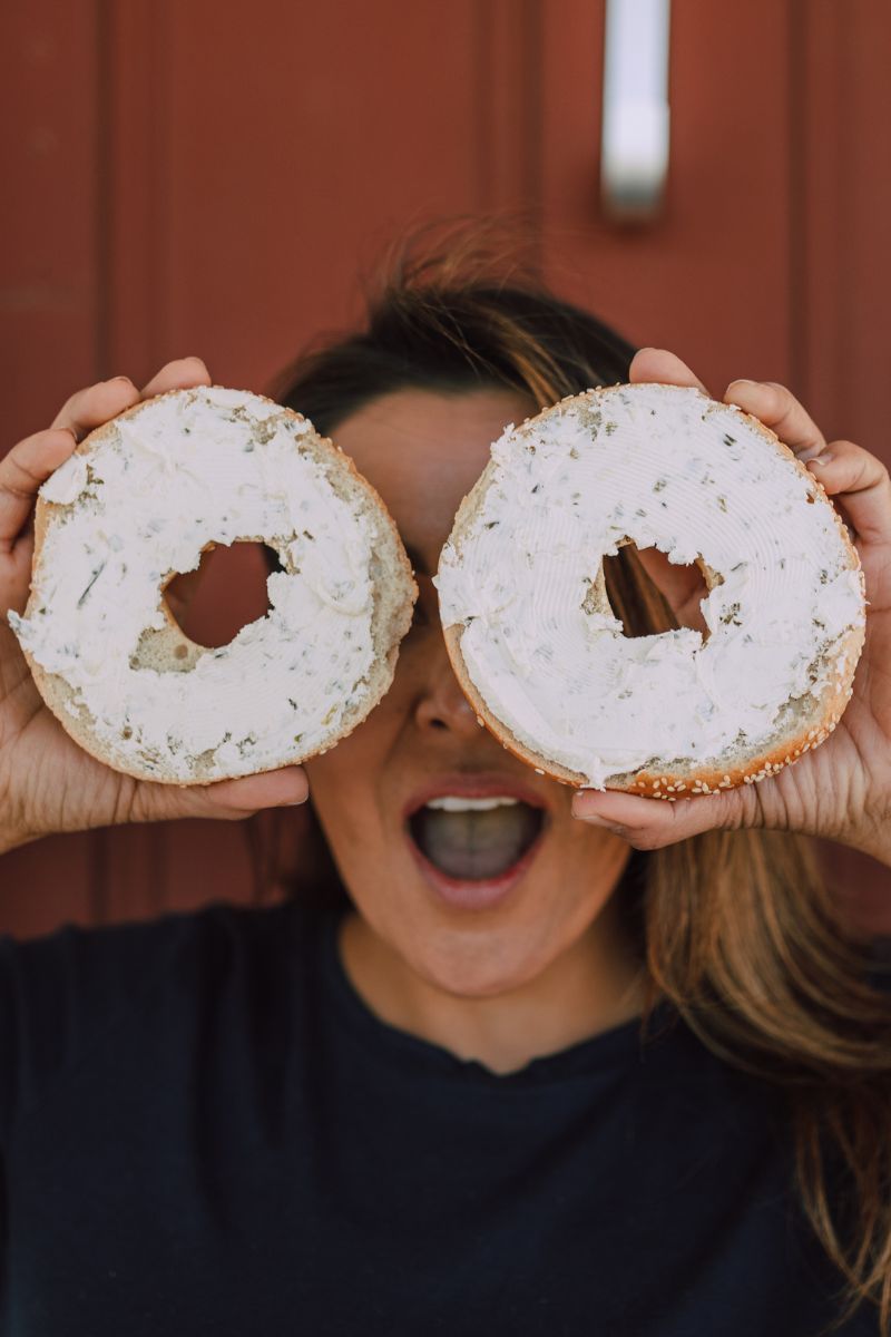 How to soften cream cheese quickly. A lady holding two bagels with cream cheese in front of her eyes. 