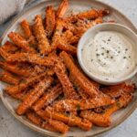 A plate of air-fried carrots with a dipping sauce.