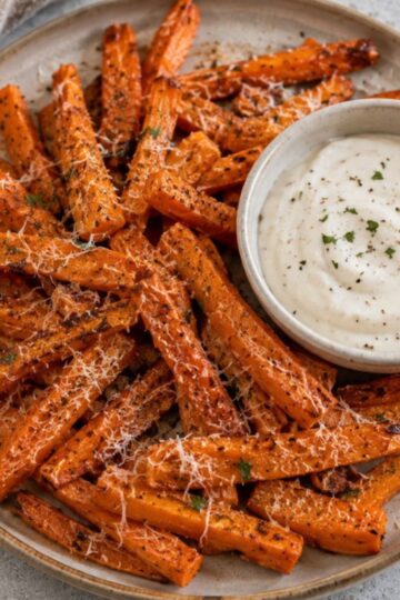 A plate of air-fried carrots with a dipping sauce.