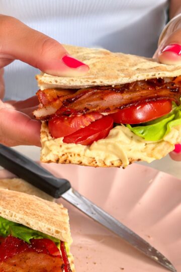 Hummus pita BLT sandwich with bacon, lettuce and tomatoes.