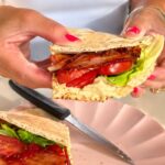 Hummus pita BLT sandwich with bacon, lettuce and tomatoes.