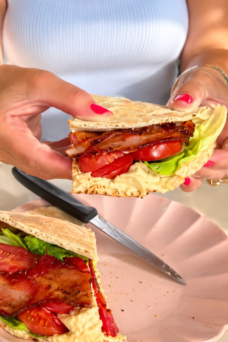 Hummus pita BLT sandwich with bacon, lettuce and tomatoes.
