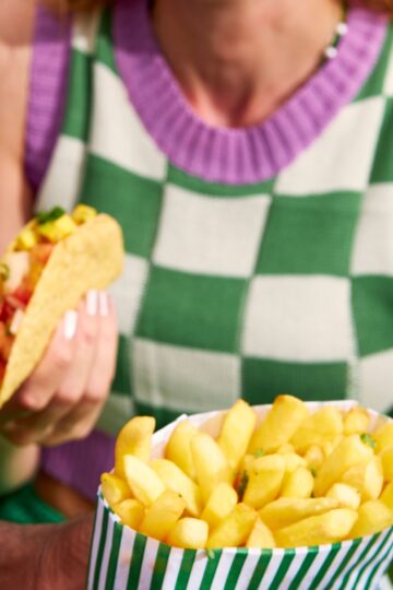 A lady eating potato fries.