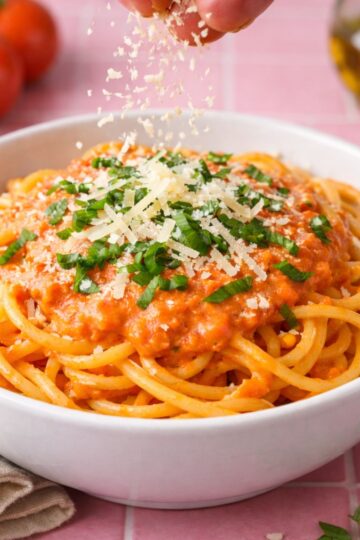 A bowl of cherry tomato spaghetti sauce with a sprinkle of Parmesan cheese.