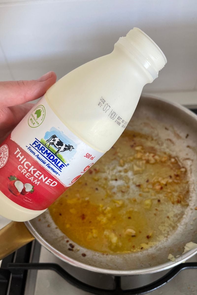 Adding cream to the sauce. 