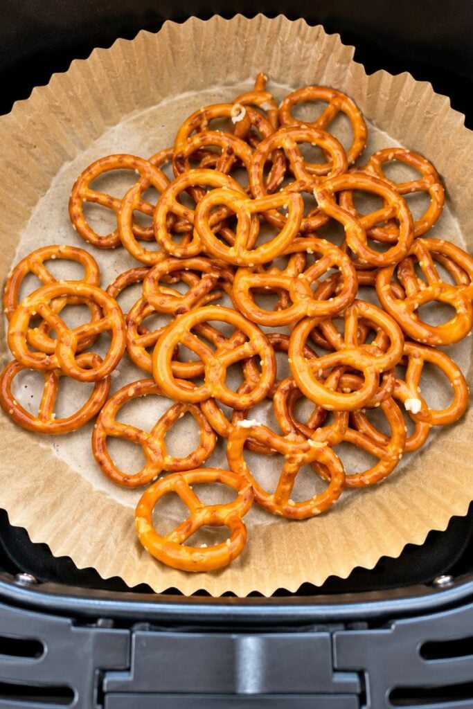 Pretzels arranged on baking paper in an air fryer.