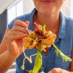 Holding a fork with crispy rice salad and chicken (high protien)