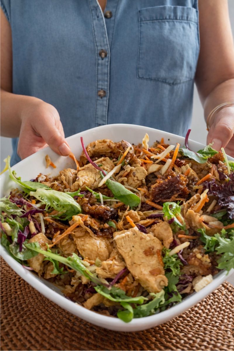 Holding a bowl of crispy rice salad. 