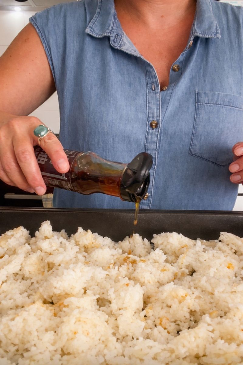 Adding sesame seed oil to the rice. 
