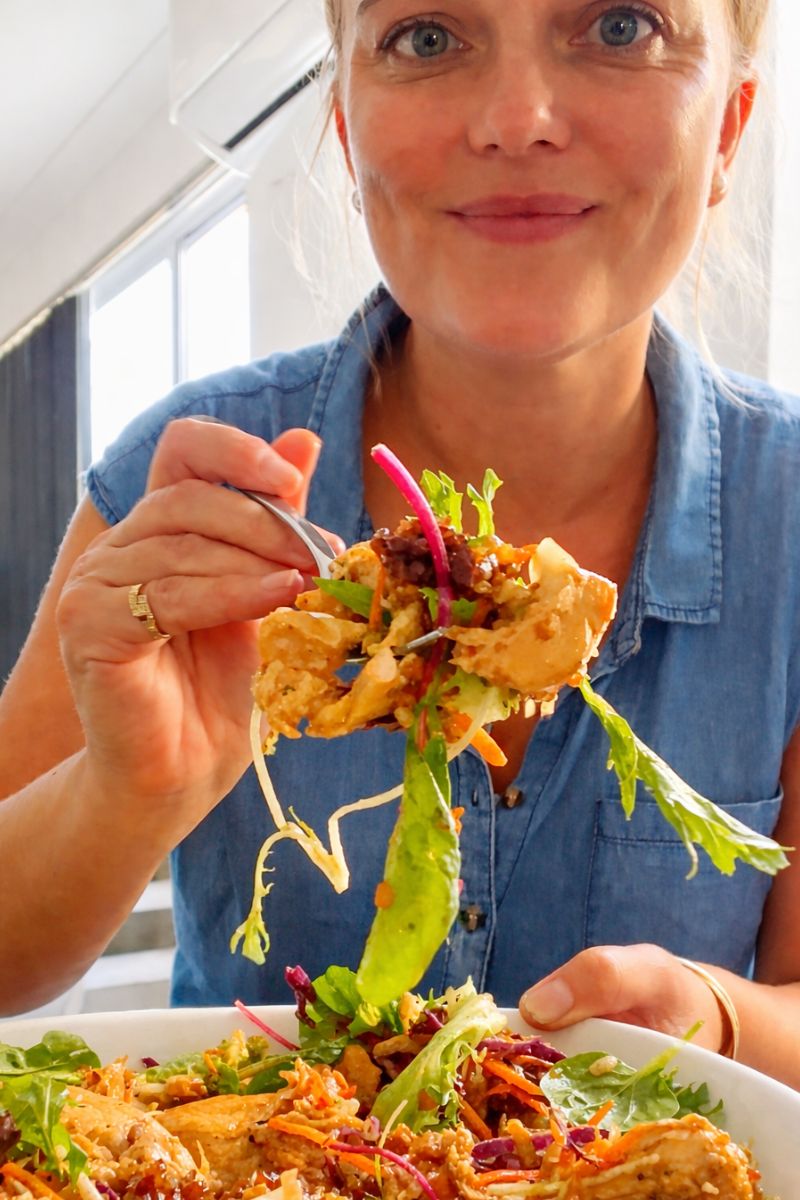 Holding a fork with crispy rice salad and chicken (high protien)