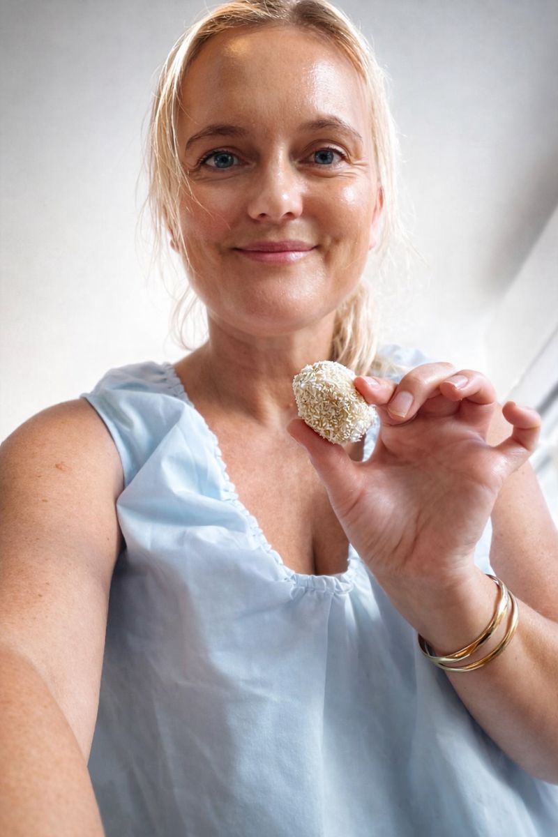 Holding a lemon energy ball. 