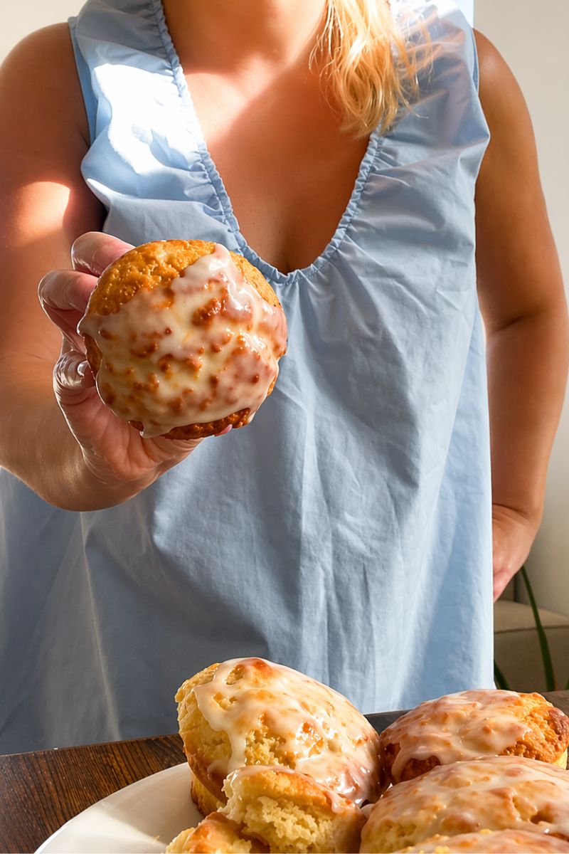 Holding a moist lemon muffin with a lemon sugar drizzle.
