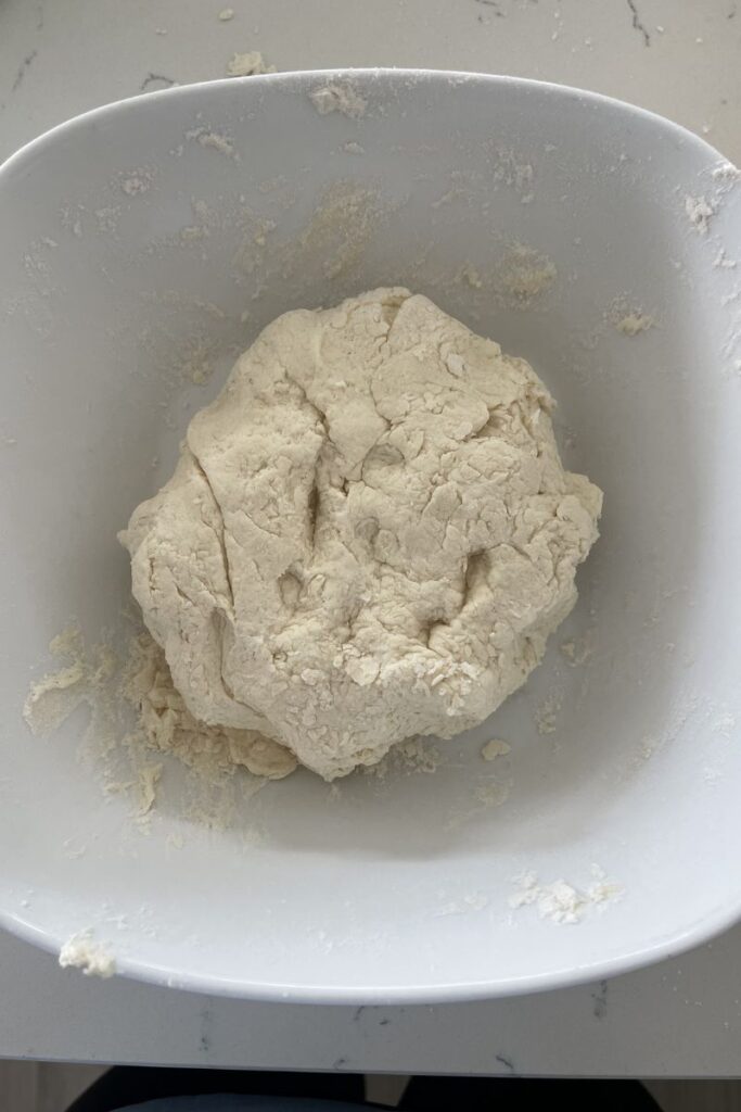 A ball of pizza dough in a bowl. 