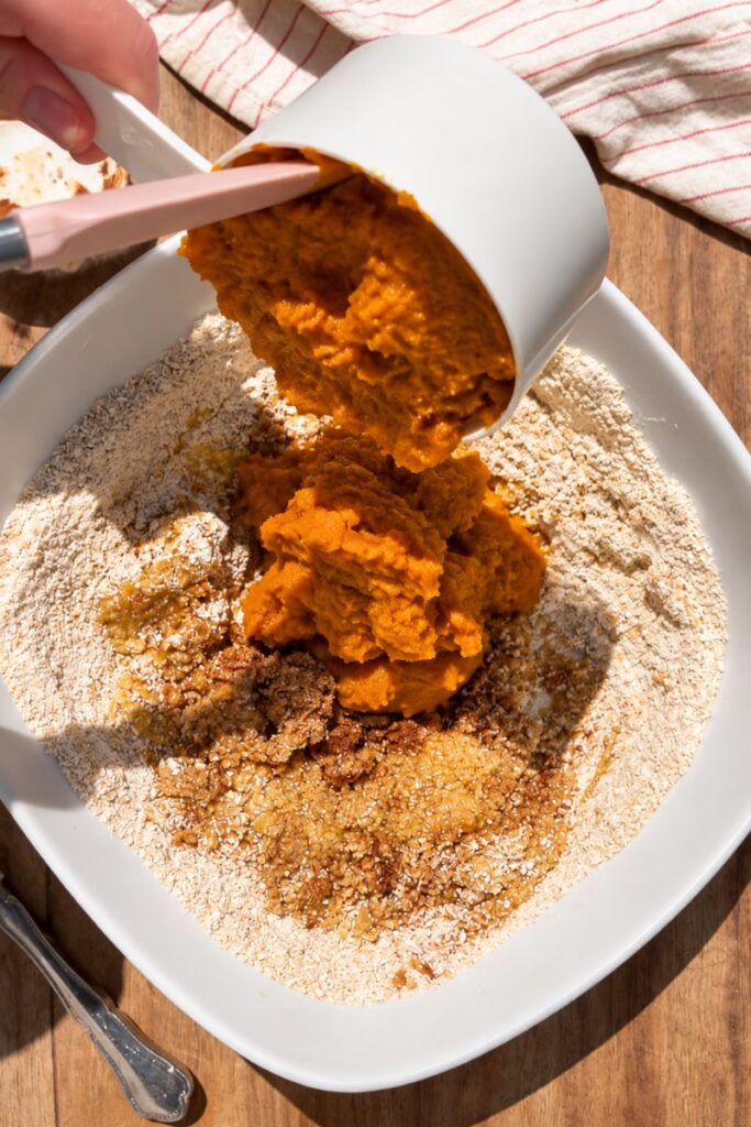 Pumpkin puree being added to the oat muffin mixture