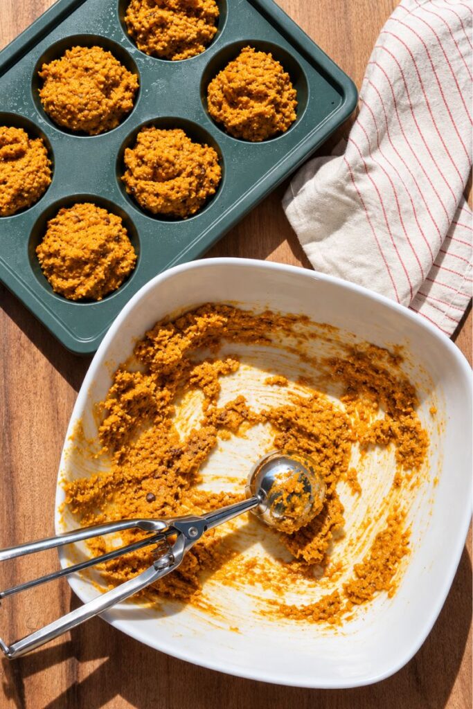 Pumpkin muffin batter divided into a muffin pan