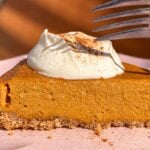 Slice of pumpkin cottage cheese cheesecake topped with Greek yogurt and cinnamon.