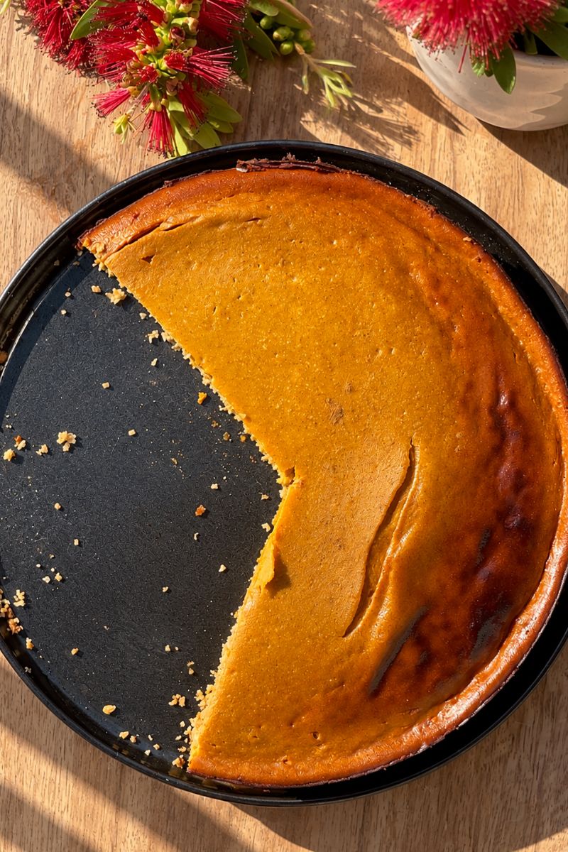 Healthy pumpkin cottage cheese cheesecake baked in a round pan.